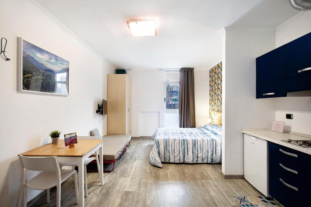 ein kleines Zimmer mit einem Tisch und einem Bett in der Unterkunft Alpen Pila Residence Loft 4 in Aosta