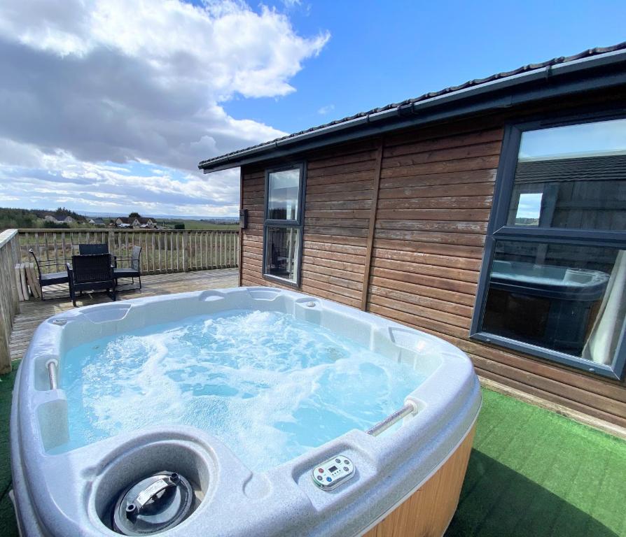 a hot tub on the back of a house at Benarty 11 with Private Hot Tub - Fife - Loch Leven - Lomond Hills - Pet Friendly in Kelty