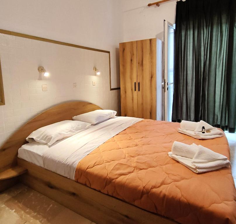 een slaapkamer met een groot bed en 2 handdoeken bij Eleni Apartments Sant George Beach in Agios Georgios