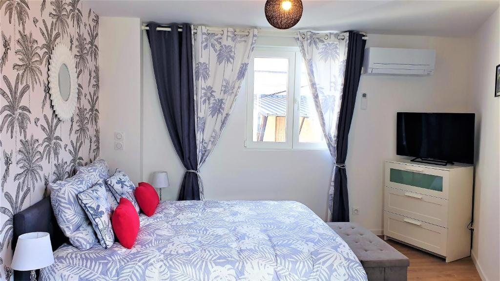 Un dormitorio con una cama con almohadas rojas y una ventana en Petit Ecrin à migennes balcon-gare-clim en Migennes