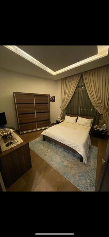 um quarto com uma grande cama branca e uma mesa em Dandon em Riyadh