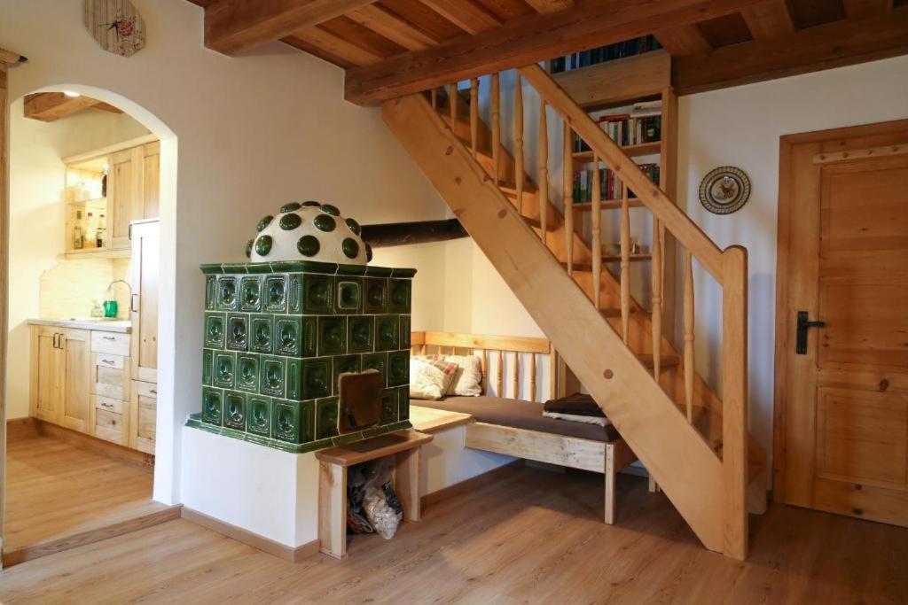 uma sala de estar com uma escada de madeira e uma cozinha em Kreitalm - Kraftplatz im Salzkammergut em Neukirchen