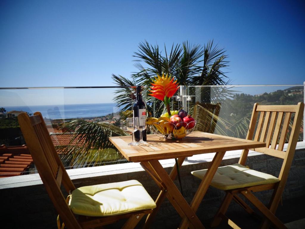 a wooden table with a bowl of fruit on a balcony at Madeira Holiday Flats in Funchal
