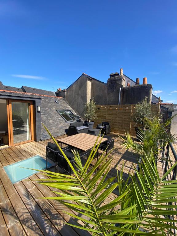 un patio avec une table et des chaises sur une terrasse dans l'établissement Duplex la parenthèse bretonne, à Auray