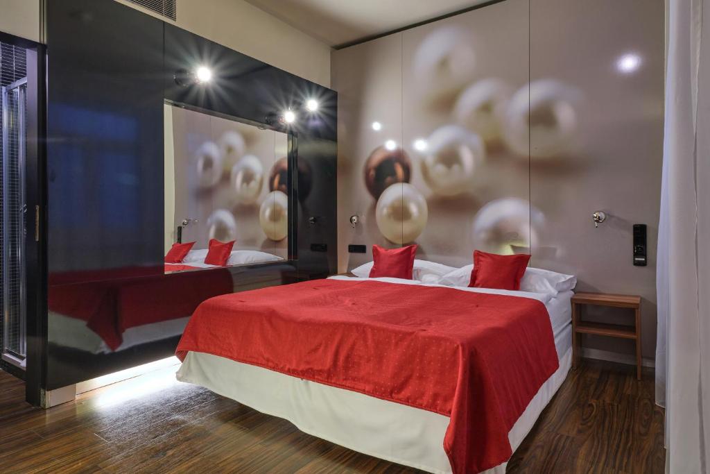 a bedroom with two beds and a red blanket at Perla Hotel in Prague