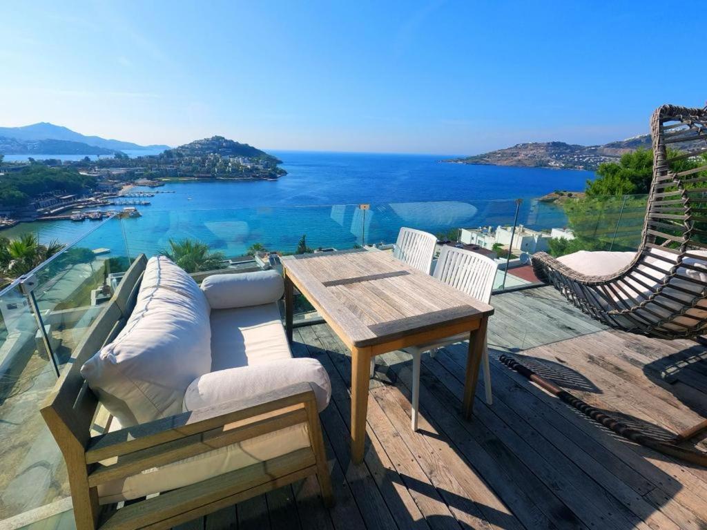 a patio with a table and chairs and a view of the water at Life Butiq Otel in Yalıkavak
