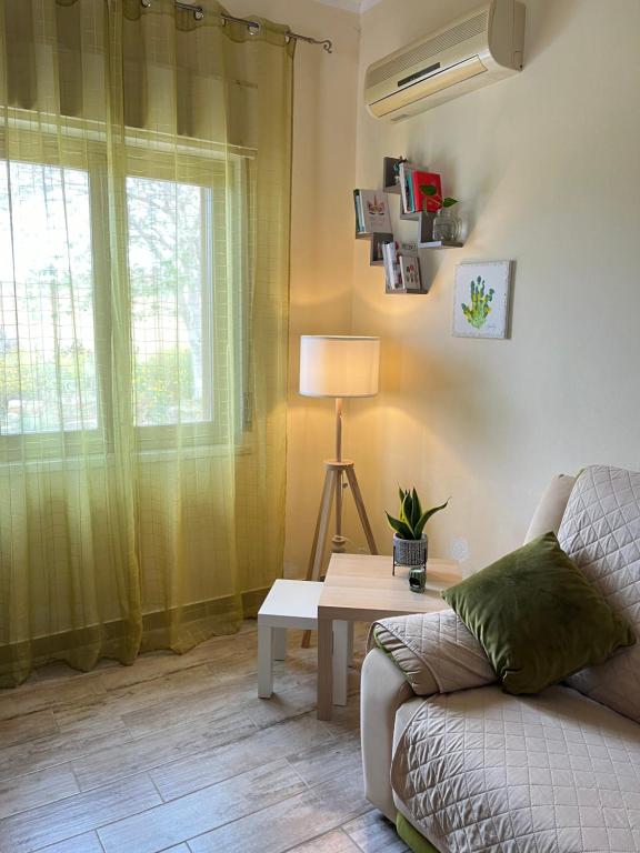 sala de estar con sofá, mesa y ventana en Casa Farinelli, en Campobello di Mazara