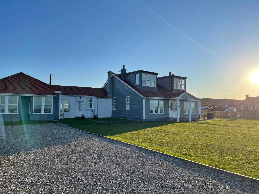 a house with the sun setting in the background at Point Cottages, Bamburgh in Bamburgh