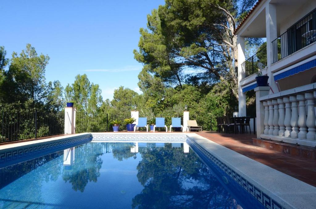 - une piscine avec 2 chaises à côté d'une maison dans l'établissement Villa Sa Punta 46, à Begur