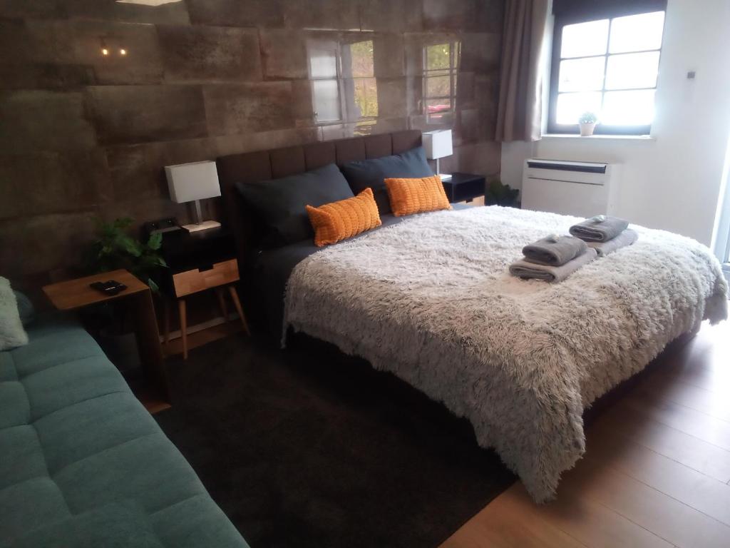 een slaapkamer met een groot bed en een bank bij Nettes Apartment priv. Eingang nähe Weinheim/HD/MA in Birkenau