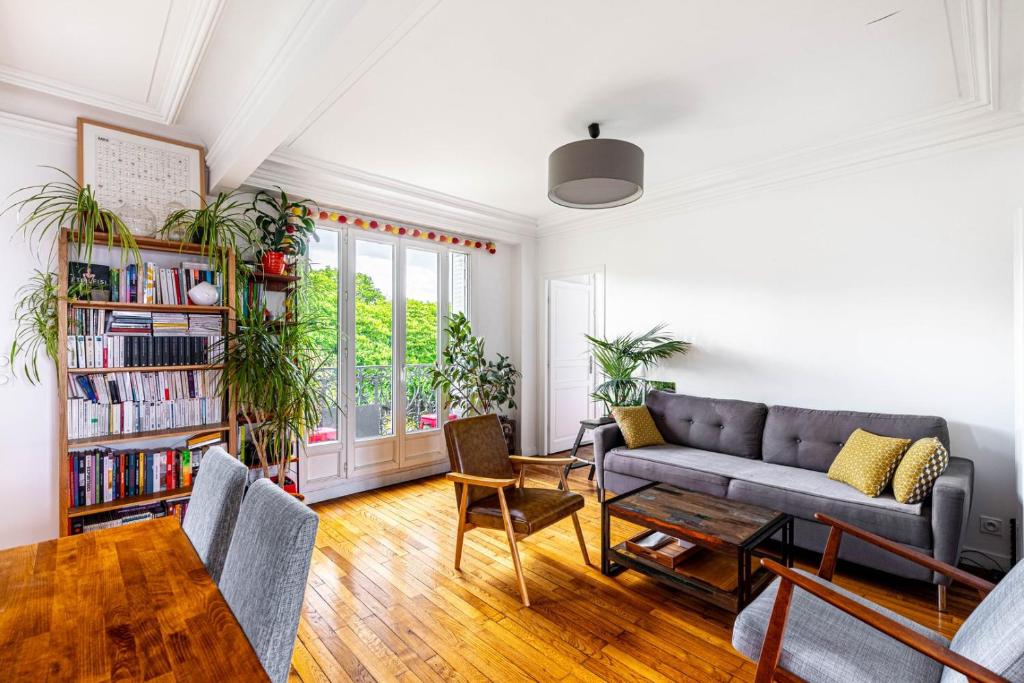 a living room with a couch and a book shelf at GuestReady - Modern stay near Atelier des Lumières in Paris