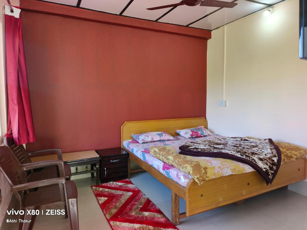a bedroom with a bed and a table and a ceiling fan at Abhi house in McLeod Ganj