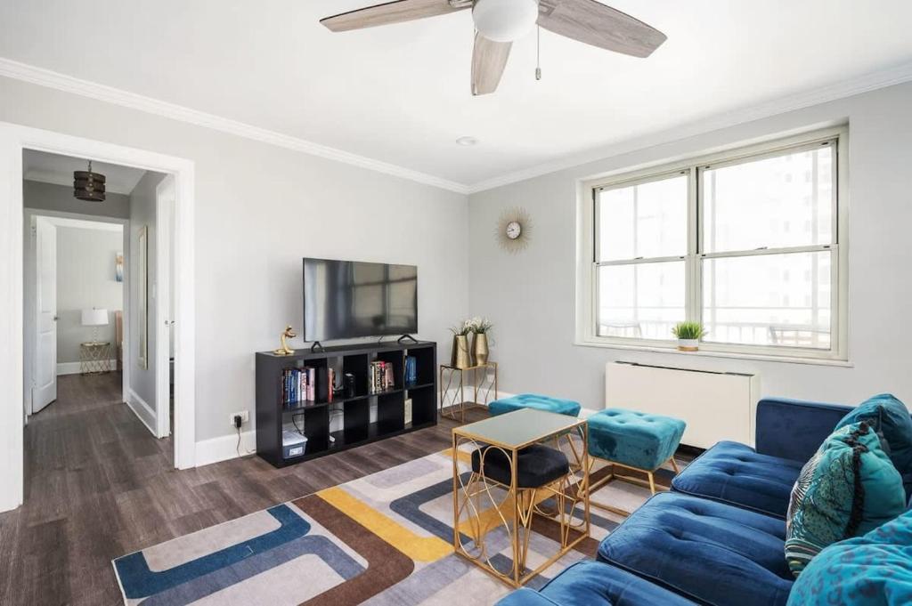 a living room with a blue couch and a tv at Center Downtown! King Bed! Private Balcony! PT8I in Atlanta