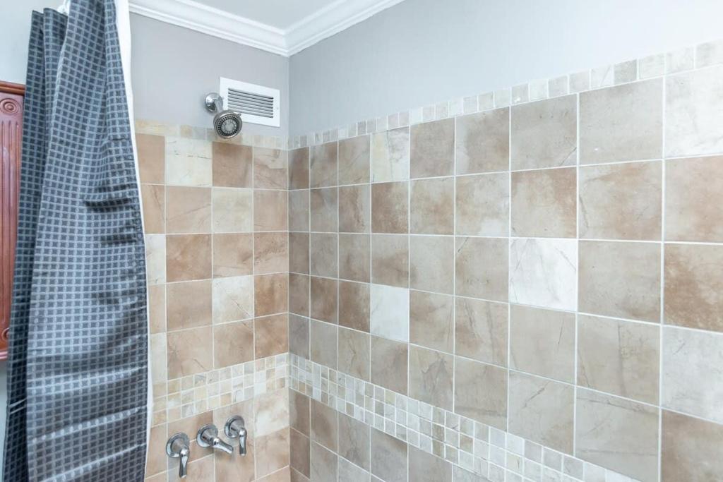 a bathroom with a shower with brown tiles at Downtown Condo! Private Balcony! 10F in Atlanta