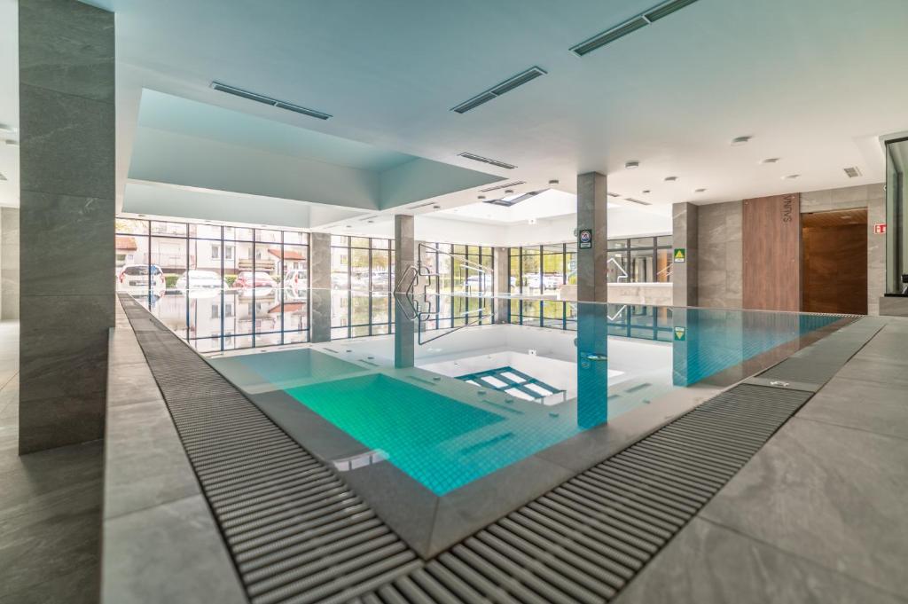 a swimming pool in the middle of a building at Nadmorski Loft GREEN PORT SPA in Kołobrzeg