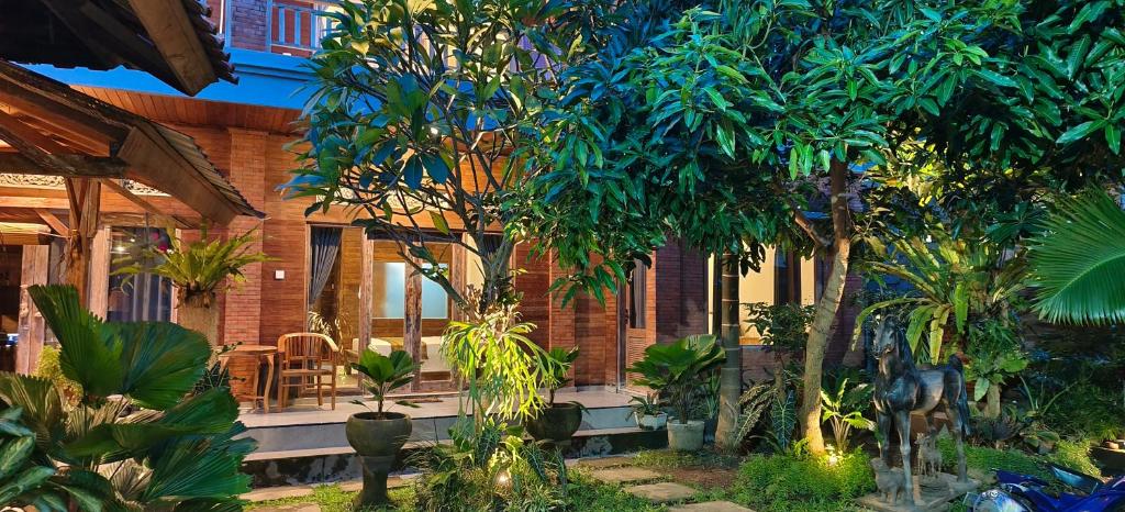 een huis met bomen en planten ervoor bij Dream house teges jati in Ubud