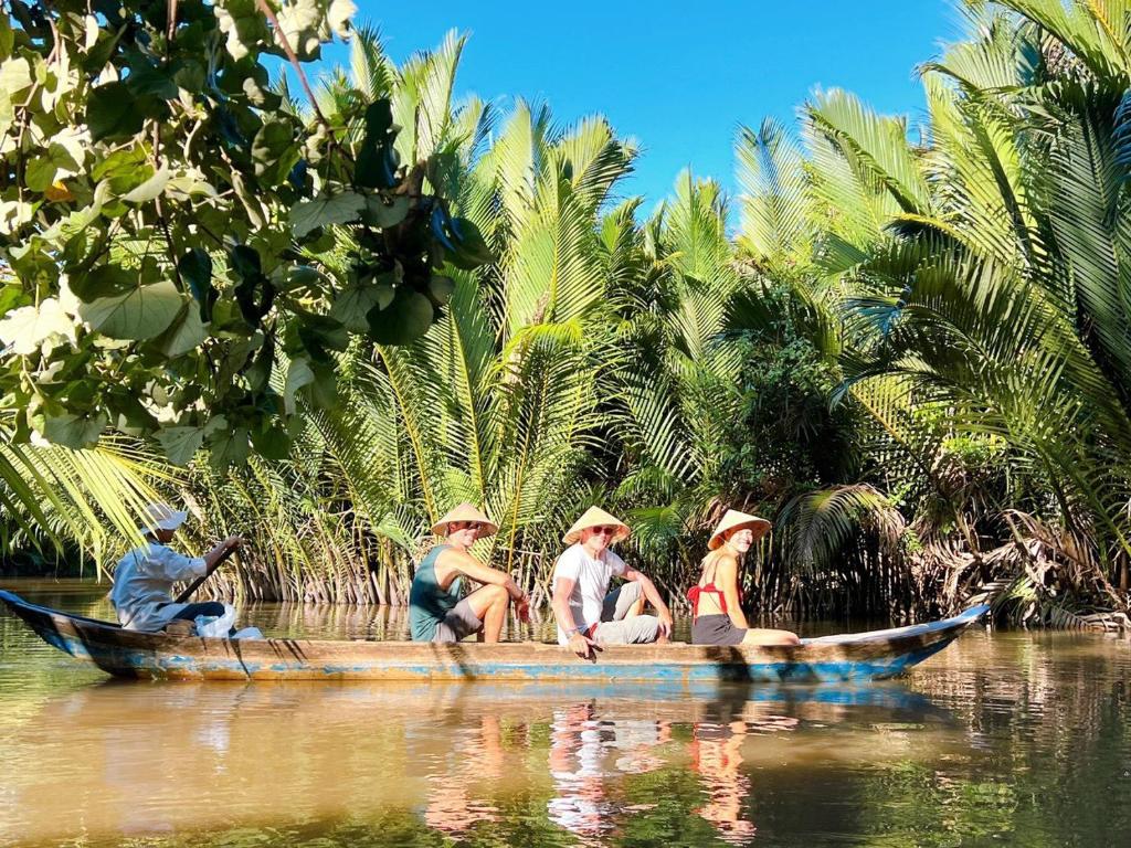 Ấp Phú Hòa (3)にあるHide Away Bungalows in Ben Tre Cityの水上の船に座る人々