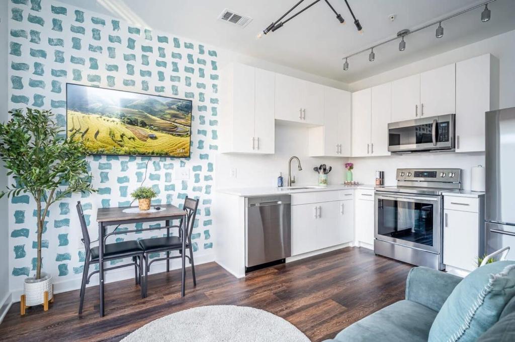 a kitchen with white cabinets and a table in a room at Luxe 1BR w Balcony in Downtown 542Blvd206 in Atlanta