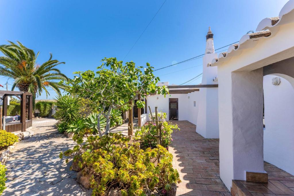a courtyard of a house with trees and plants at Sagres, Aloha Beach House, 500 meters from Tonel beach in Sagres