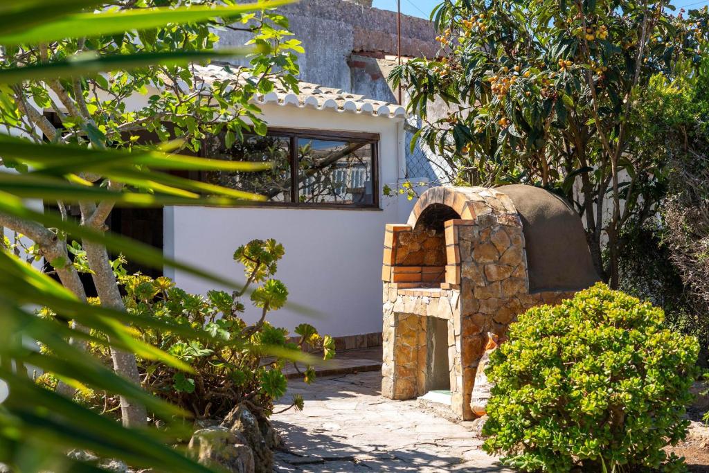 a house with a stone oven in a yard at Sagres, Aloha Beach House, 500 meters from Tonel beach in Sagres