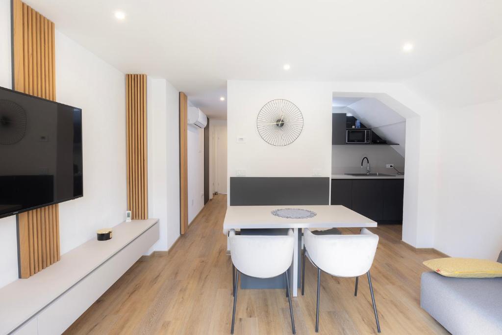 a kitchen and living room with a table and chairs at Apartments BB in Bohinj