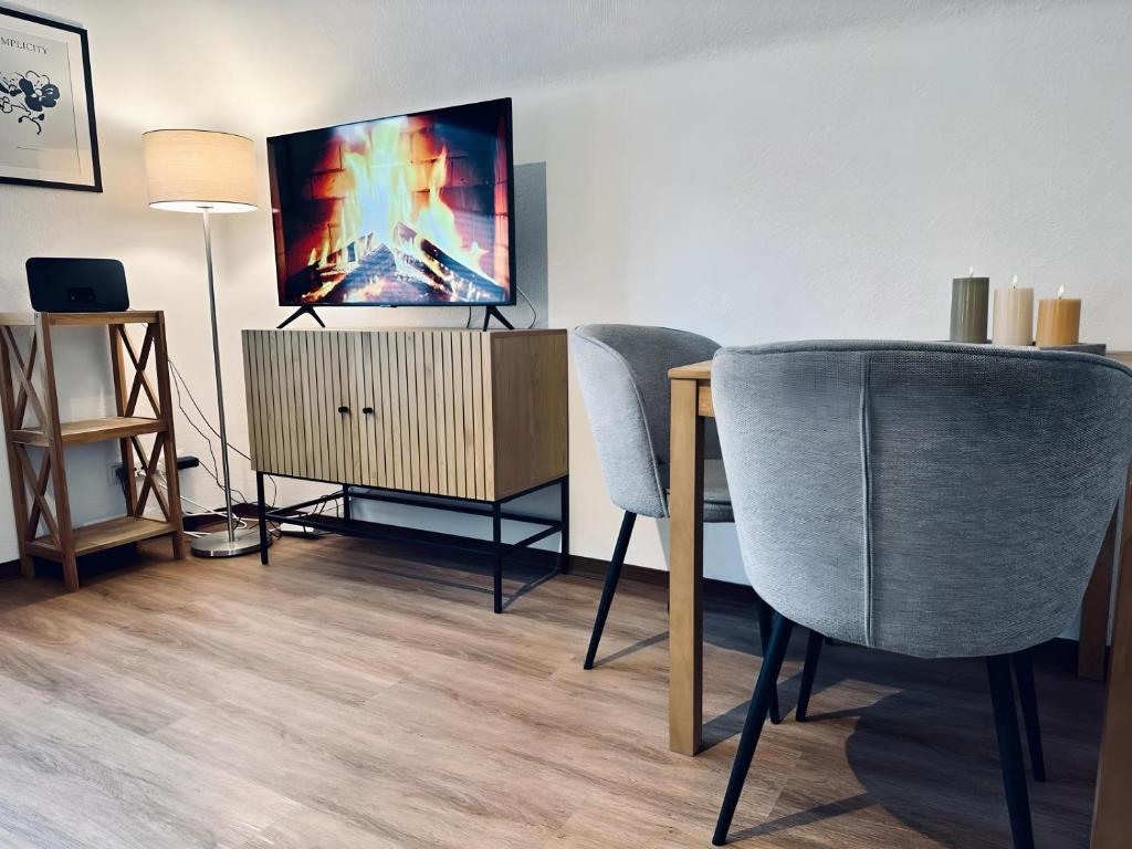 uma sala de estar com 2 cadeiras e uma televisão de ecrã plano em FeWo Burgnest em Bad Bentheim