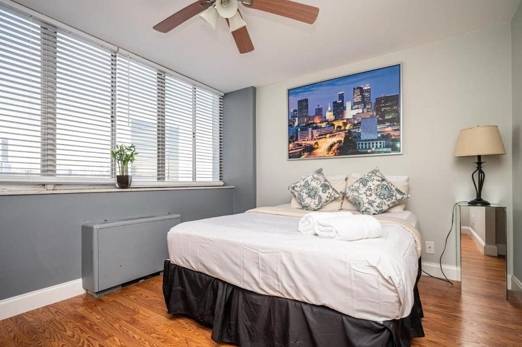 Schlafzimmer mit einem Bett, einem Deckenventilator und Fenstern in der Unterkunft ATL Downtown City View Onsite Parking 1B1B LM810 in Atlanta