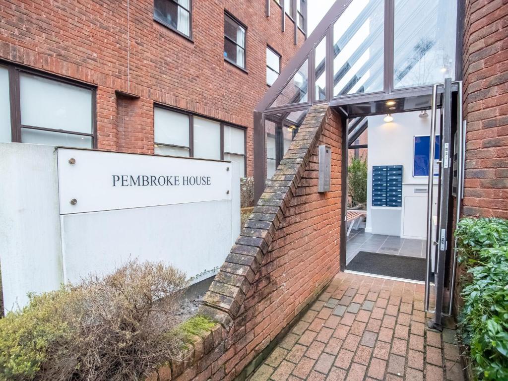 een bakstenen gebouw met een bord dat pantomop huis leest bij Pembroke House Apartments Exeter For Families Business Relocation Free Parking in Exeter