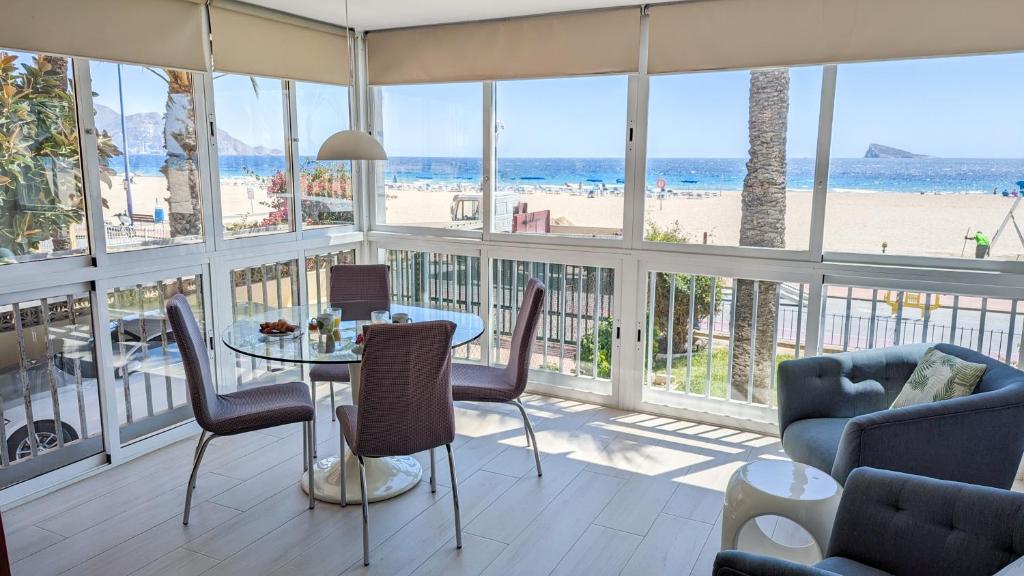 a dining room with a table and chairs and the beach at ESMERALDA sea front apartment in Benidorm