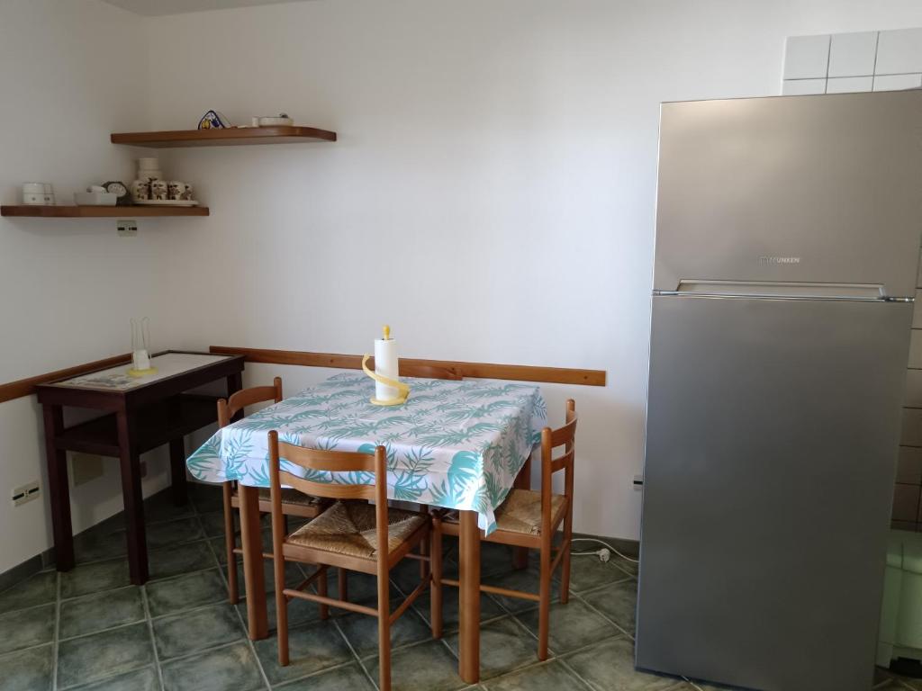 a kitchen with a table and a refrigerator at Casa Beatrice in Specchiolla