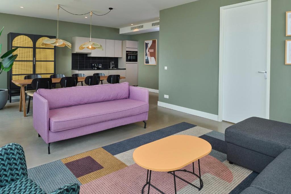 a living room with a purple couch and a table at Cityden BoLo District in Amsterdam