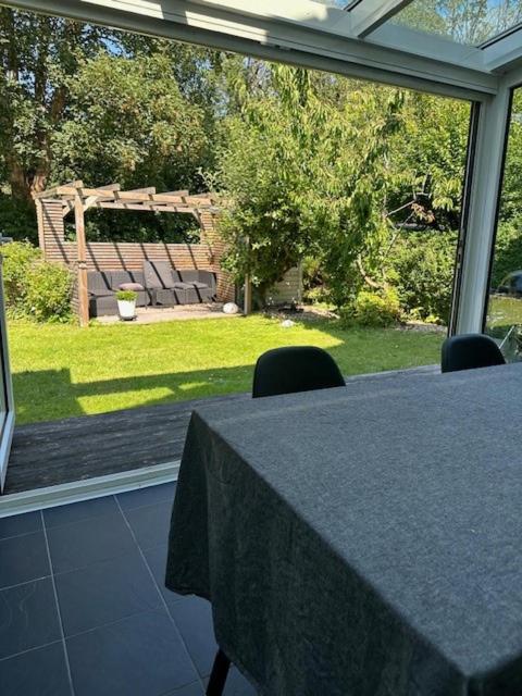 uma mesa com cadeiras em frente a uma grande janela em Casa Abba em Lomma