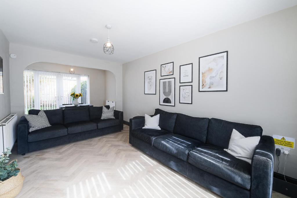 a living room with two black couches at Poppy's Place - Manningham Road in Liverpool