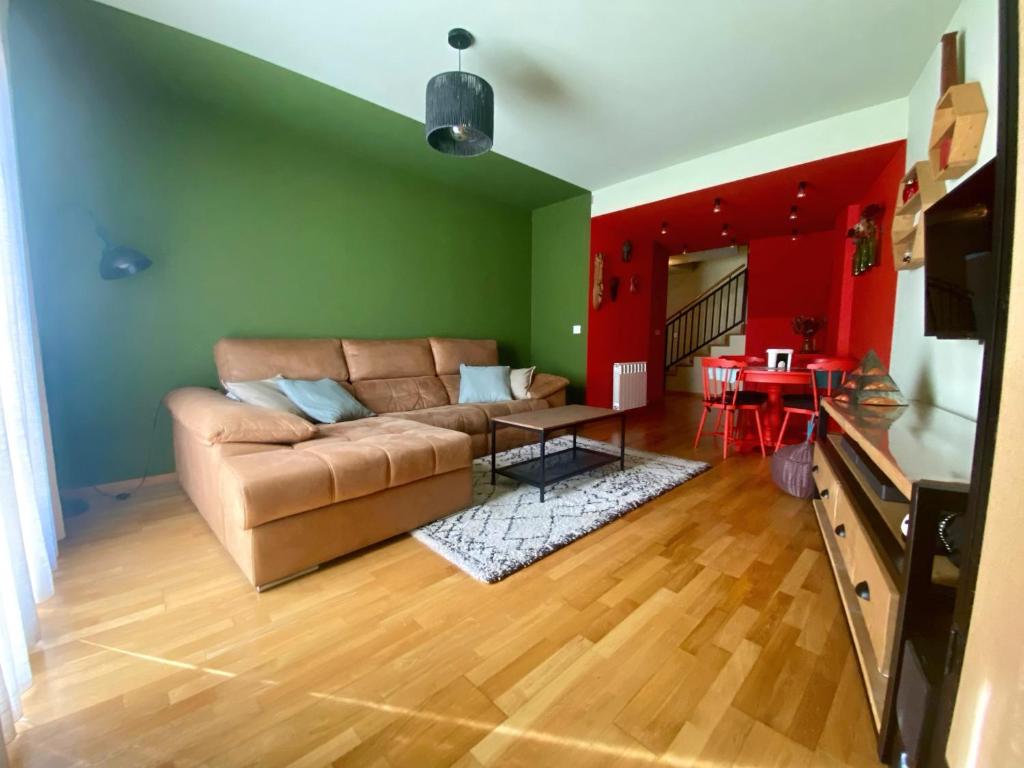 a living room with a brown couch and a red wall at Dúplex en el corazón de Haro in Haro