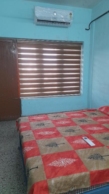 a bedroom with a bed in a room with a window at Kairali Lodge in Trichūr