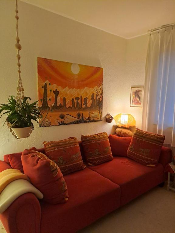 a red couch with pillows in a living room at African Dream in Oldenburg