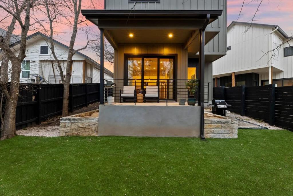 uma casa com um alpendre com uma cerca em Comfortable stay with a backyard & workspaces em Austin