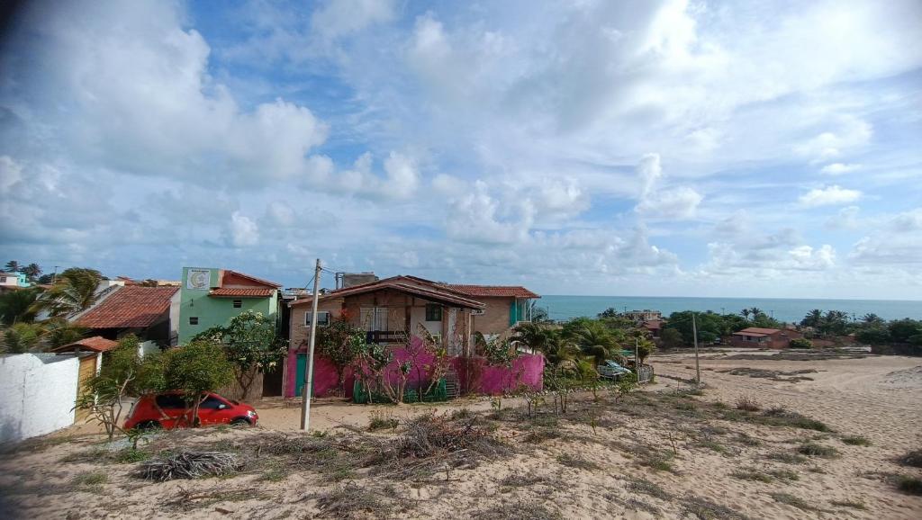 a house on the side of a hill with the ocean at Suítes Preguiça in Canoa Quebrada