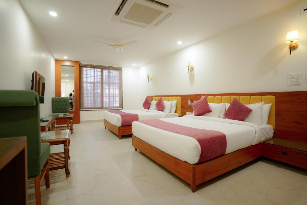 a hotel room with two beds and a desk at SoonStay Heera Residency in Bhopal