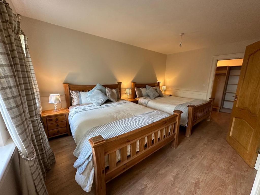 a bedroom with two beds and a window at 'Emily' Deluxe Family Room in Foxford