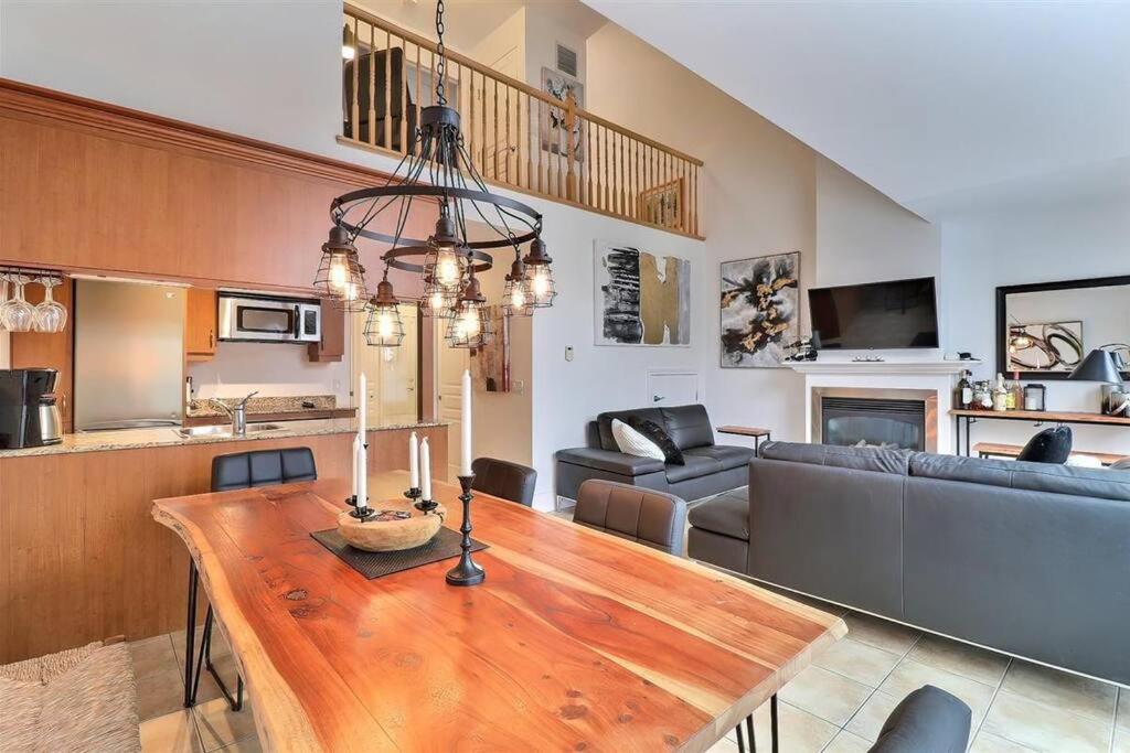 a living room with a wooden table and a dining room at Chalet Saint-Sauveur with heated pool! in Saint-Sauveur-des-Monts