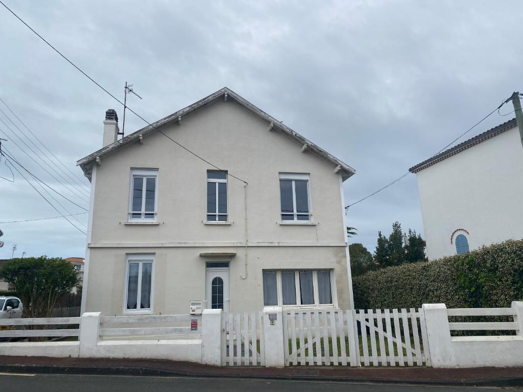 une maison blanche avec une clôture blanche devant elle dans l'établissement Élégante Villa centre ville Royan proche plages 3 chambres 3 grands lits, à Royan