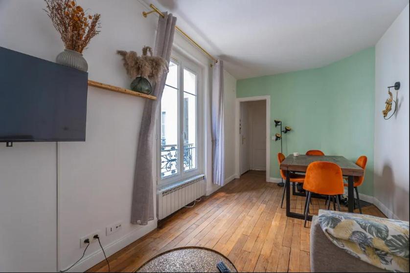 un salon avec une table et une fenêtre dans l'établissement Appartement parisien (12ème), à Paris