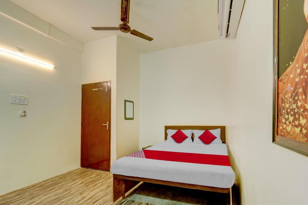 a bedroom with a bed with red pillows on it at OYO Flagship Hotel The Olive Stay in Patna