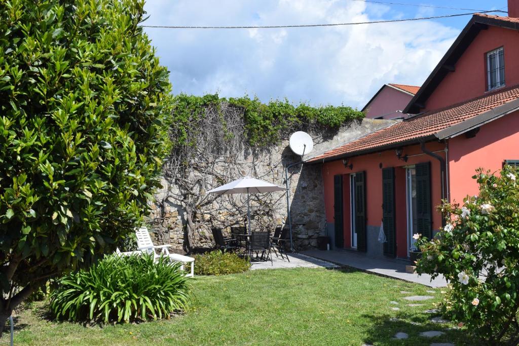 迪亞諾馬里納的住宿－Casa a Diano con giardino，一个带遮阳伞和房子的花园