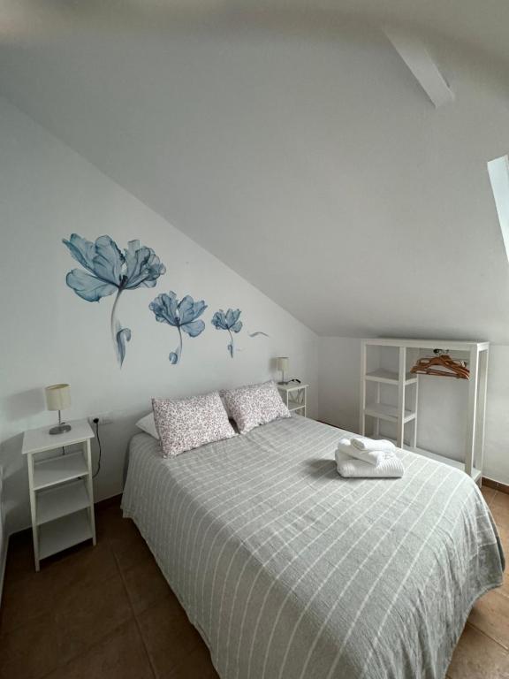 a bedroom with a bed with blue flowers on the wall at Son de Mar 2 in Bolonia