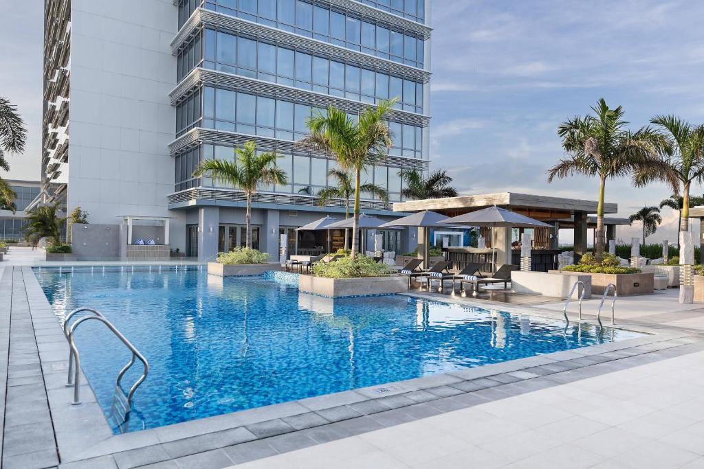 a large swimming pool in front of a building at Courtyard by Marriott Iloilo in Iloilo City