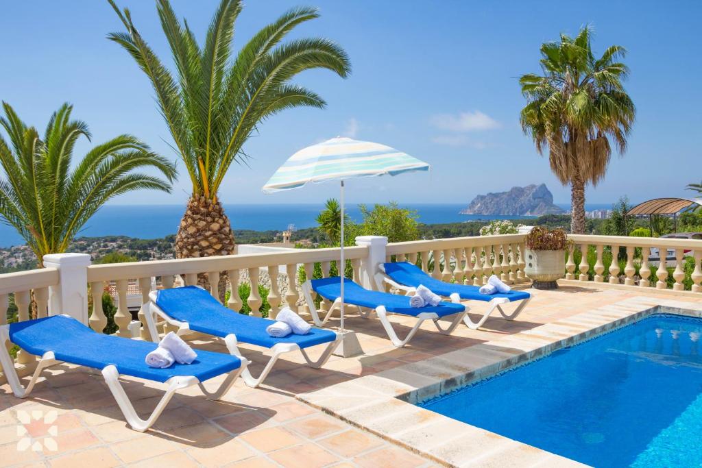 a villa with a swimming pool and palm trees at Villa Albatros by Abahana Villas in Benissa
