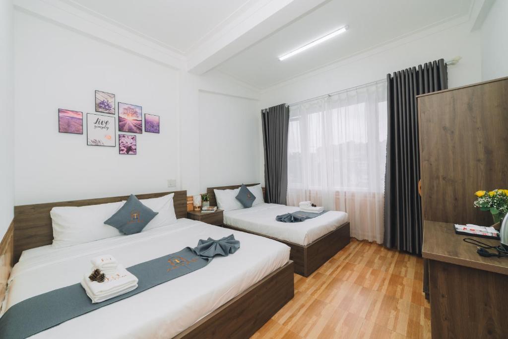 um quarto com 2 camas e uma janela em AN TÂM House Đà Lạt em Da Lat