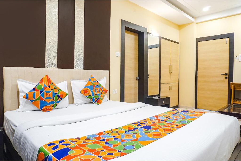 a bedroom with two beds with colorful pillows at FabHotel Krishna Regency in Pune